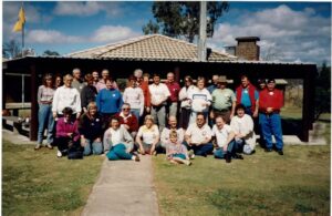Members of the Lions Club of Brisbane Camp Hill Carindale gathered outdoors in front of a park shelter.