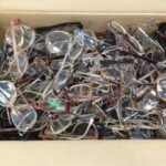 A cardboard box full of used eyeglasses collected for recycling